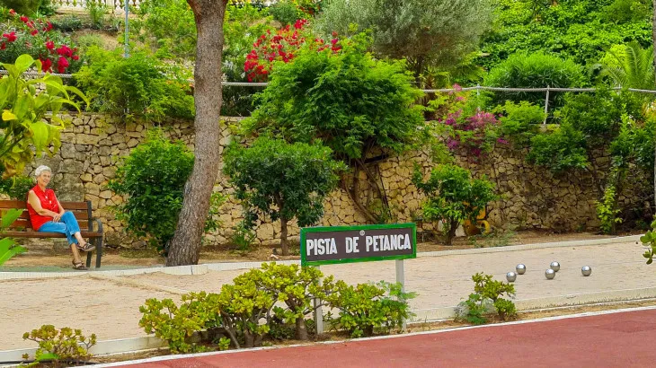 Senior person relaxing watching a game of petanque at Ciudad Patricia Retirement Resort near Benidorm in Spain Senior person relaxing watching a game of petanque at Ciudad Patricia Retirement Resort near Benidorm in Spain